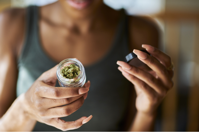 A woman holding a jar of cannabis.