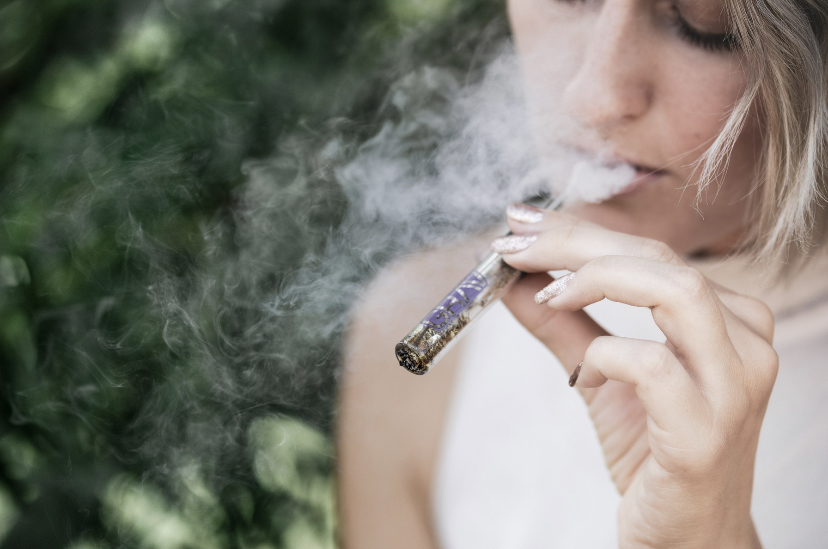 A woman using a glass blunt.